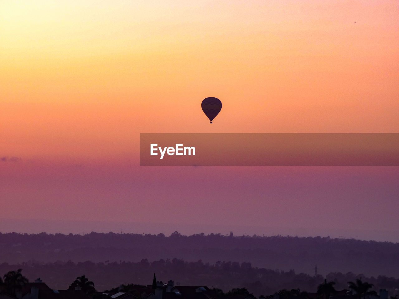 SILHOUETTE HOT AIR BALLOONS FLYING IN SKY DURING SUNSET