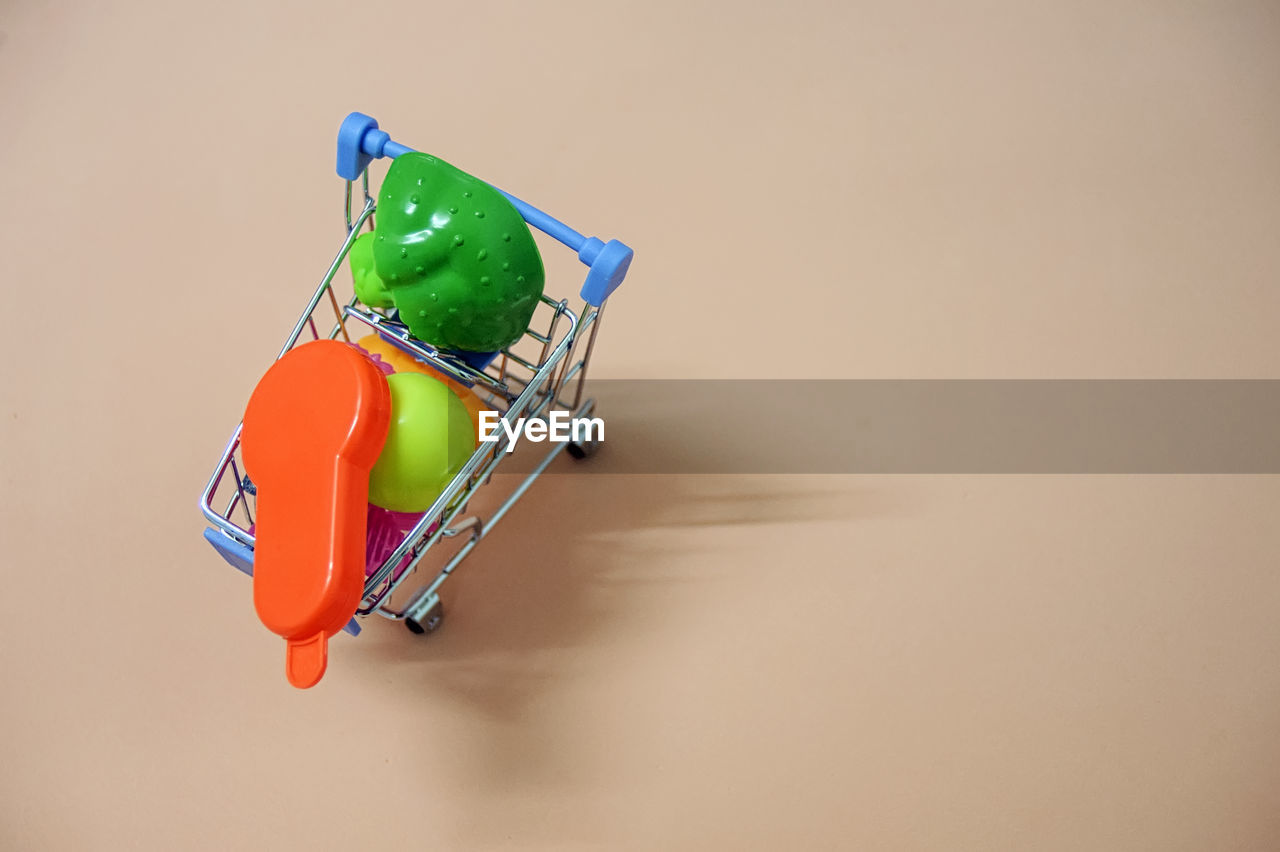 High angle view of toys in miniature shopping cart on table