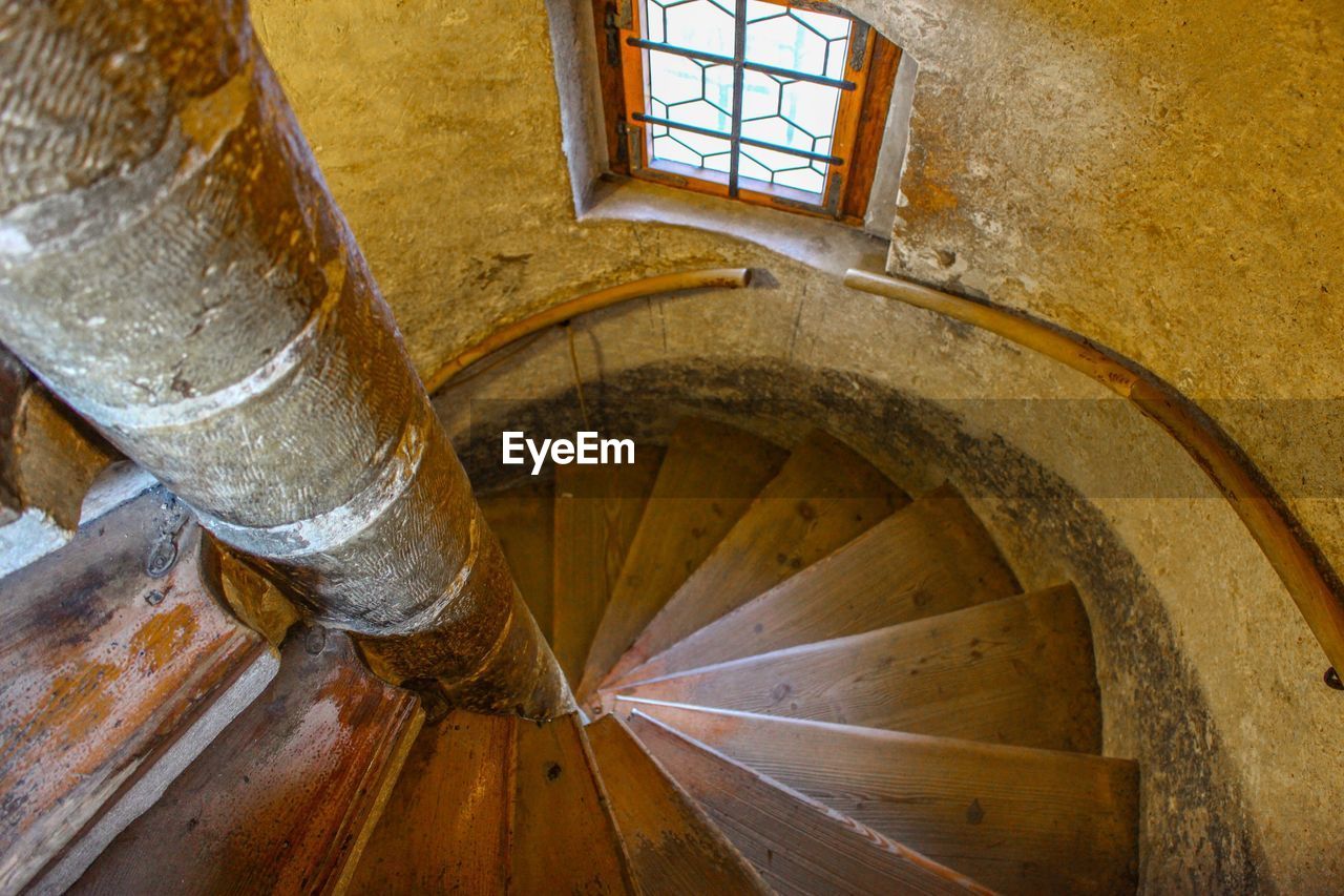 LOW ANGLE VIEW OF SPIRAL STAIRCASE IN SUNLIGHT