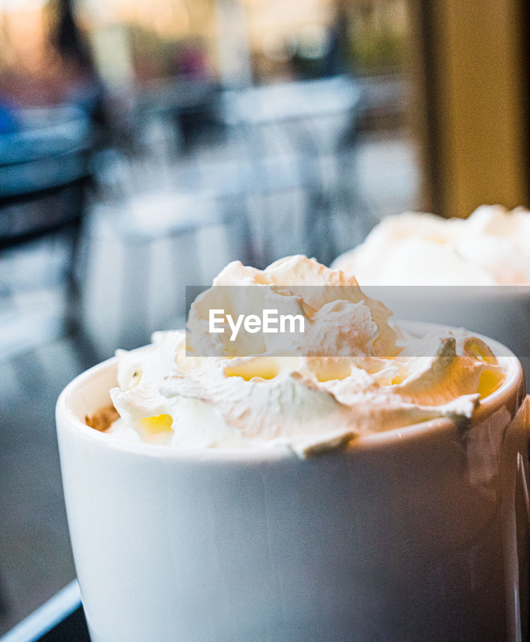 Close-up of a mug of hot chocolate with cream on a table