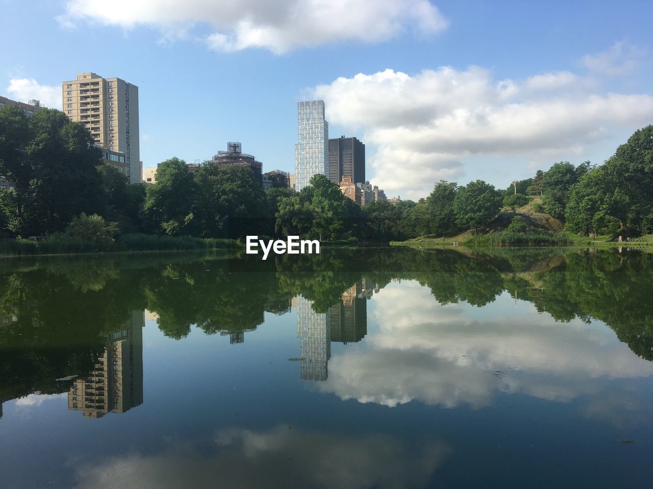 REFLECTION OF TREES AND BUILDINGS IN LAKE