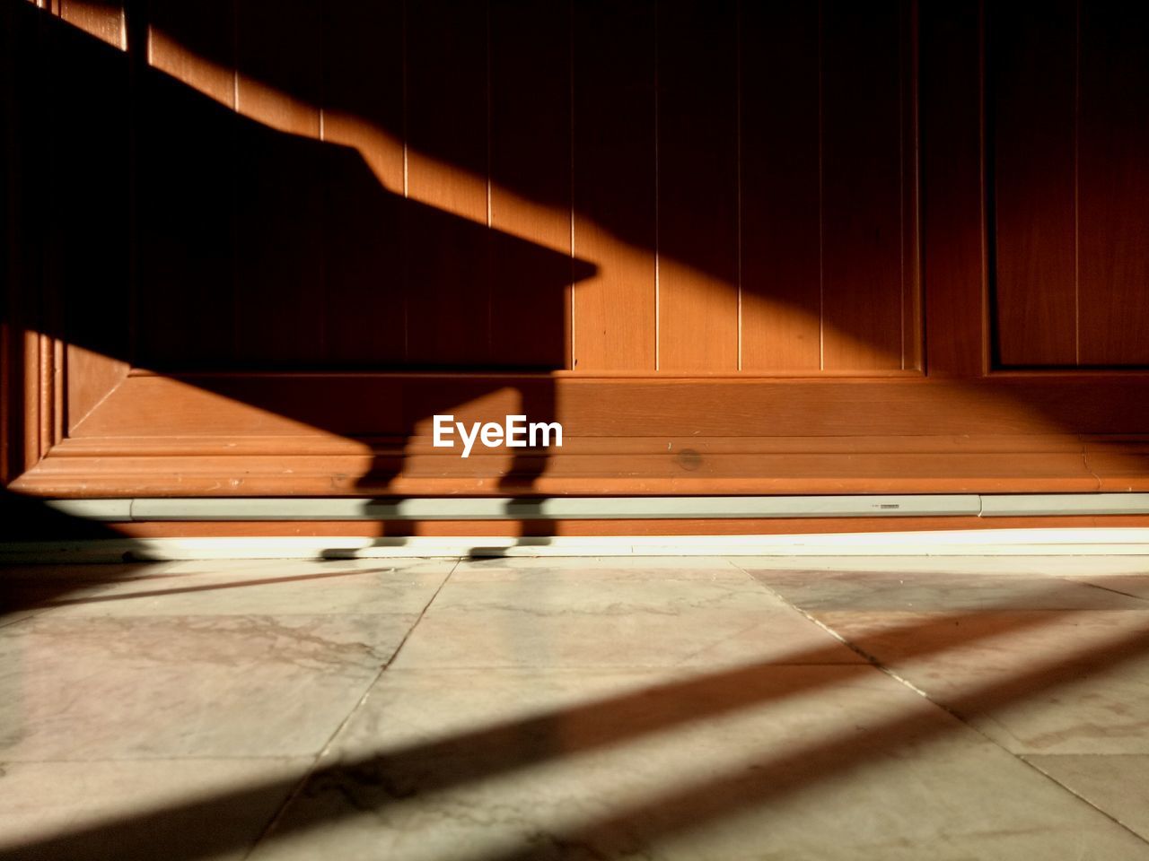 LOW SECTION OF ILLUMINATED SHADOW ON FLOOR