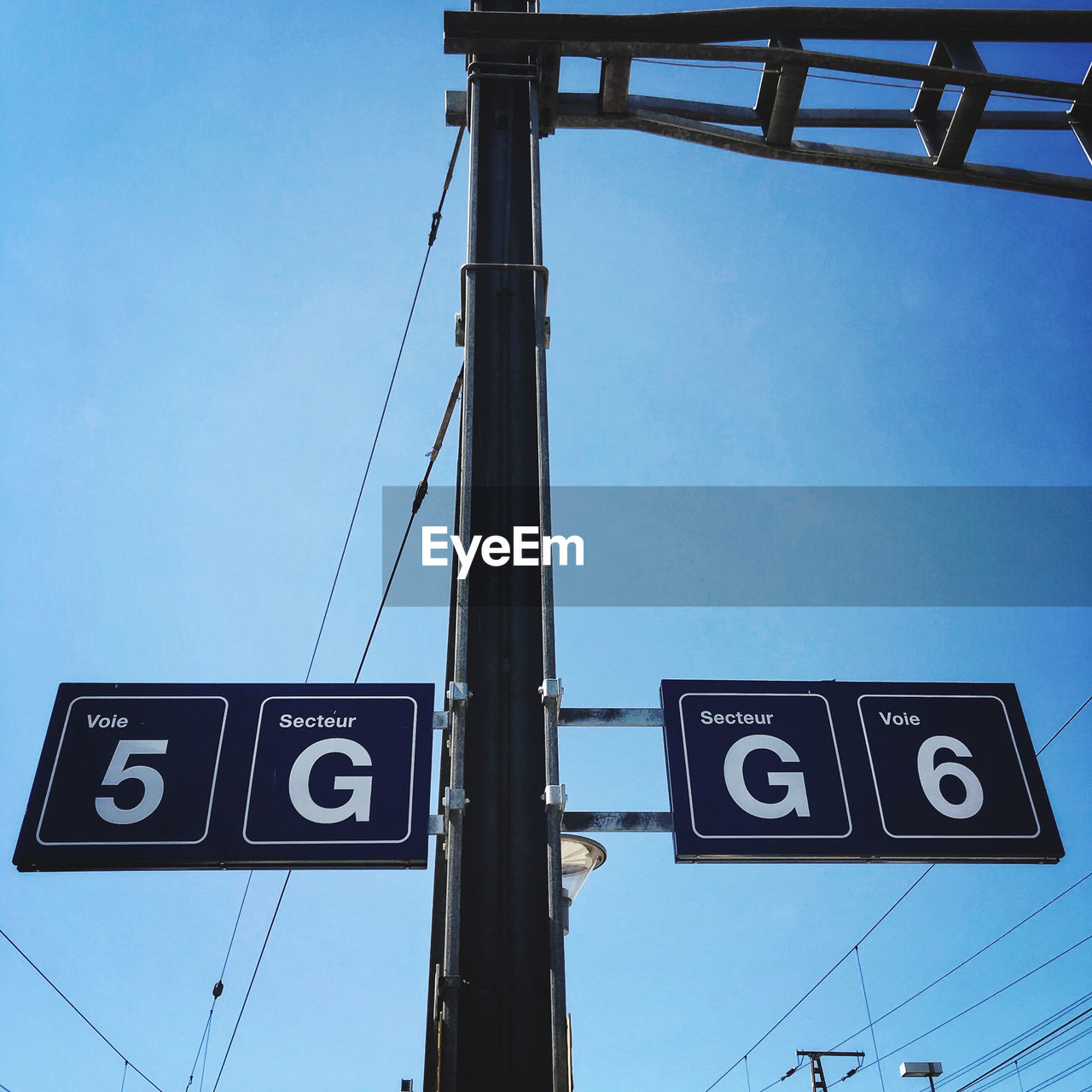 LOW ANGLE VIEW OF ROAD SIGNS AGAINST BLUE SKY