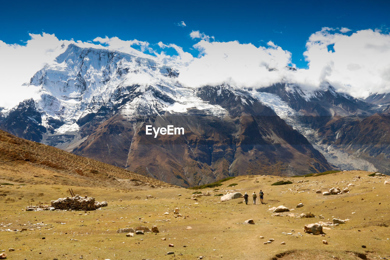 People walking against snowcapped mountains