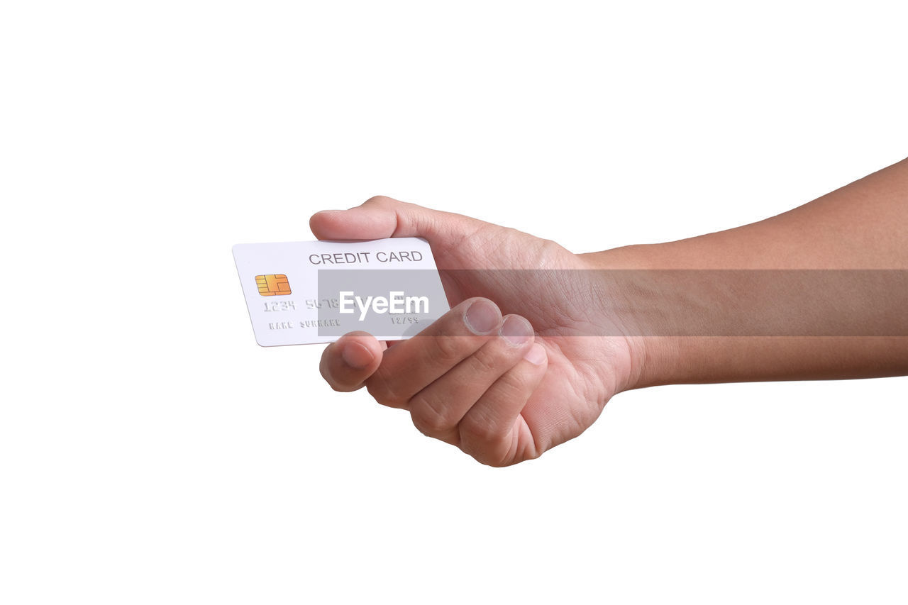 CLOSE-UP OF HAND HOLDING RING OVER WHITE BACKGROUND