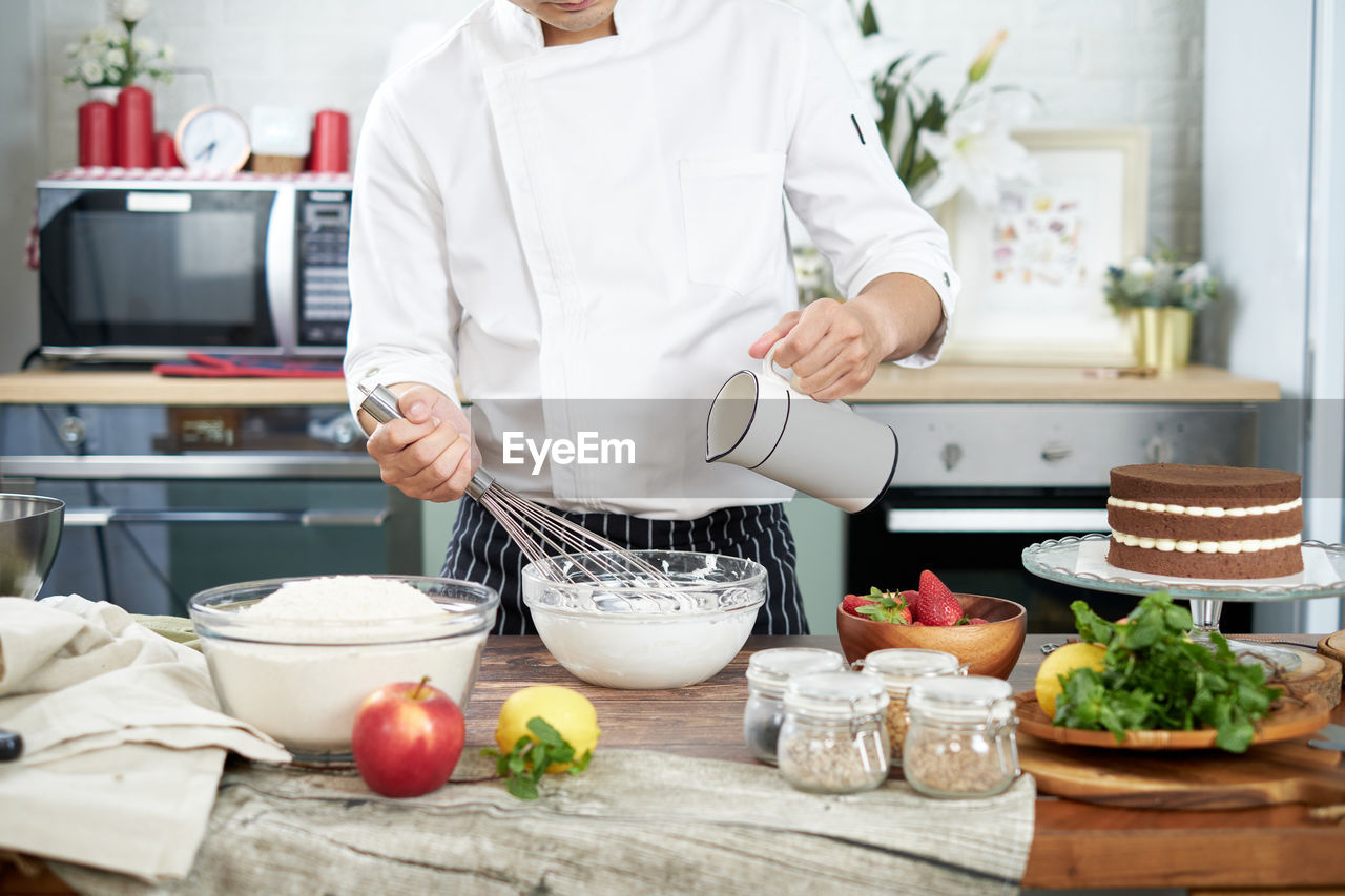 MIDSECTION OF MAN PREPARING FOOD