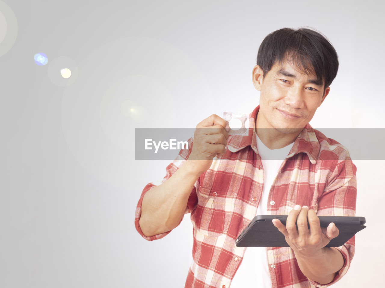 PORTRAIT OF SMILING MAN HOLDING SMART PHONE WHILE STANDING ON STREET