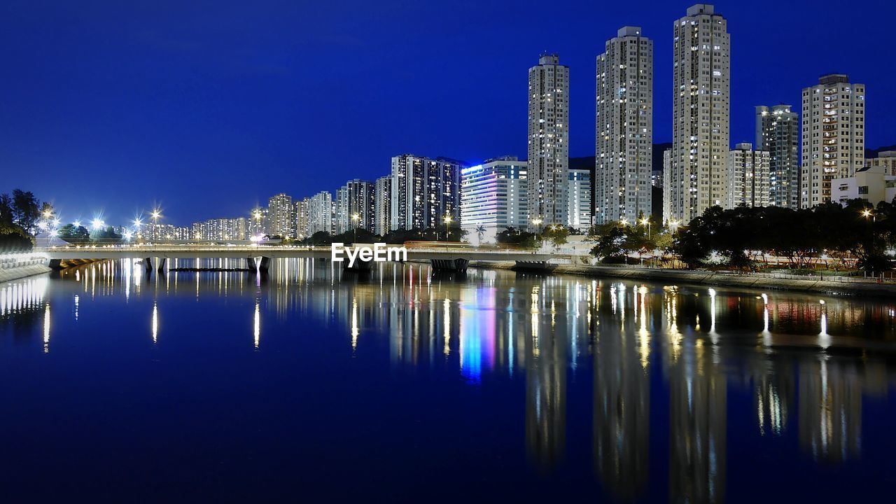 Shing mun river in front of buildings against clear sky at night