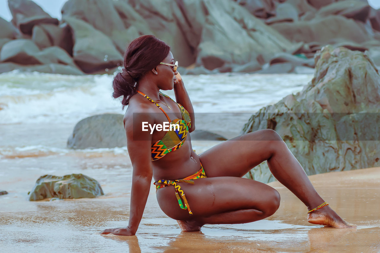 Africa ghana woman enjoying on a beach in axim ghana west africa with traditional african swimwear 