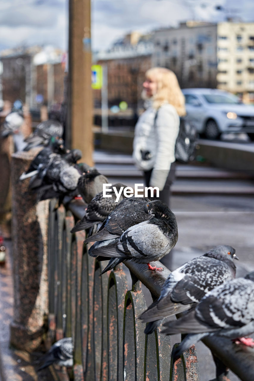 FULL LENGTH OF YOUNG WOMAN WITH BIRDS IN BACKGROUND