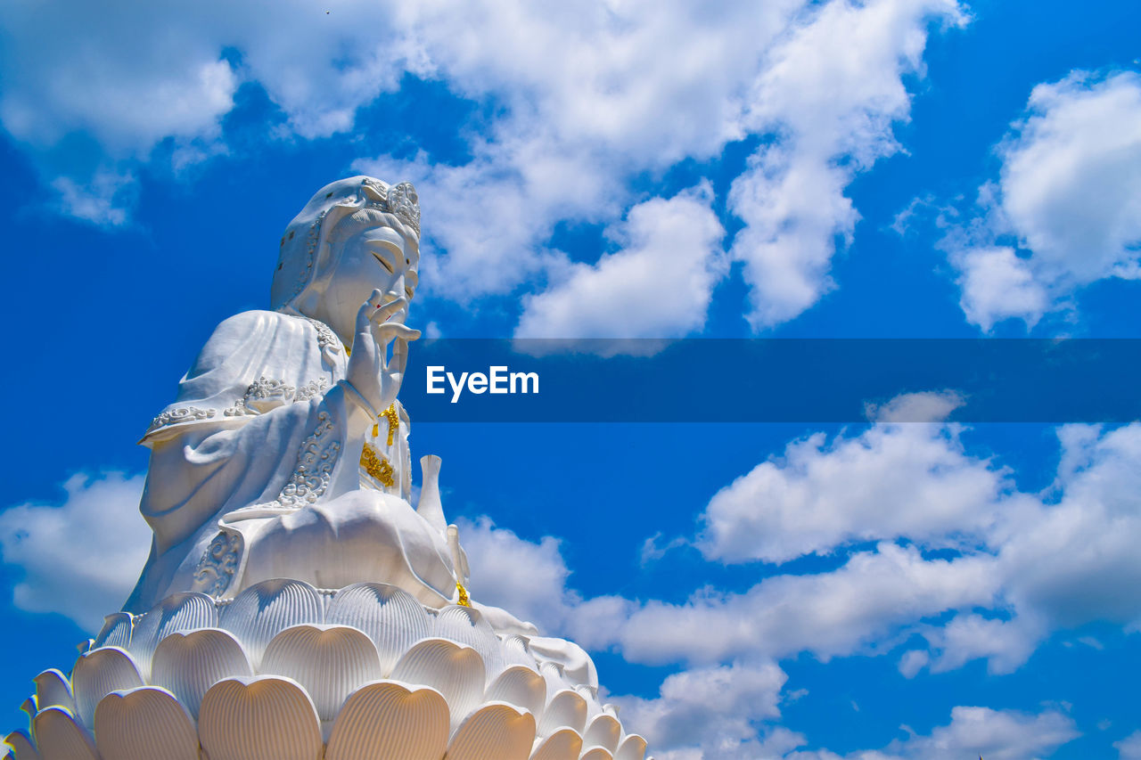 Low angle view of statue against cloudy blue sky