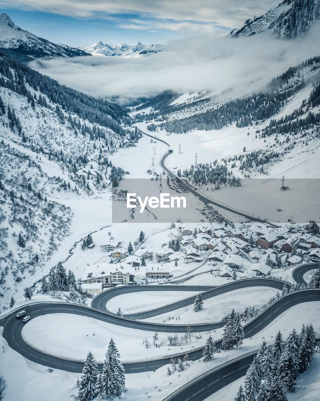 Scenic view of winding road on snow covered mountains 