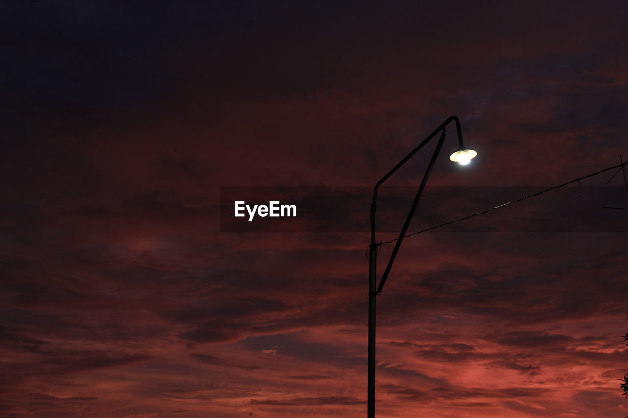 Low angle view of illuminated street light against sky at sunset