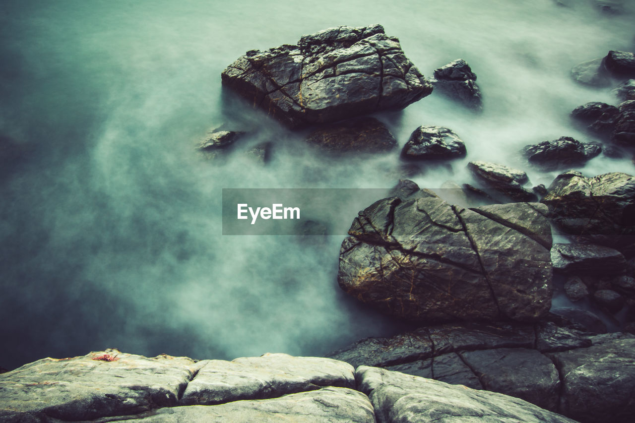 Rocks in sea against sky