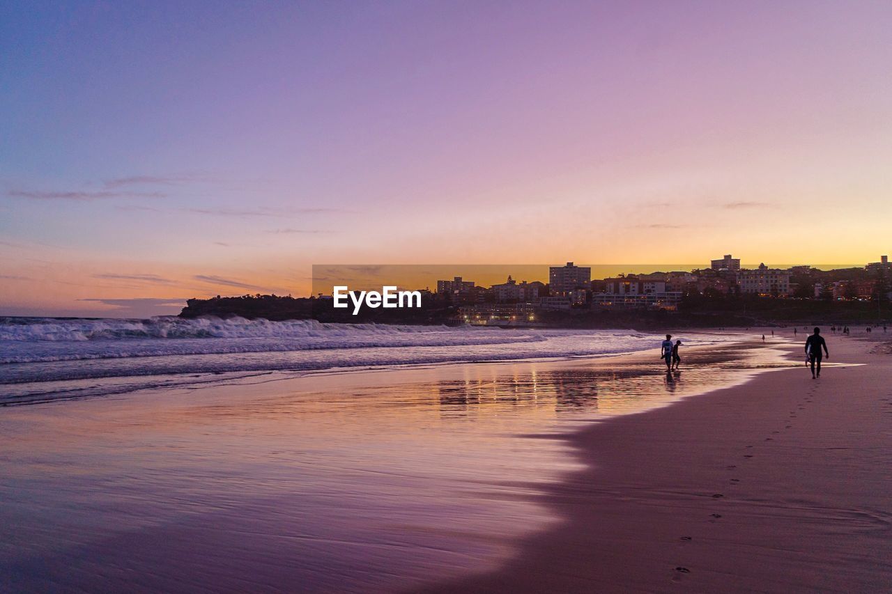 SCENIC VIEW OF BEACH AGAINST SKY AT SUNSET