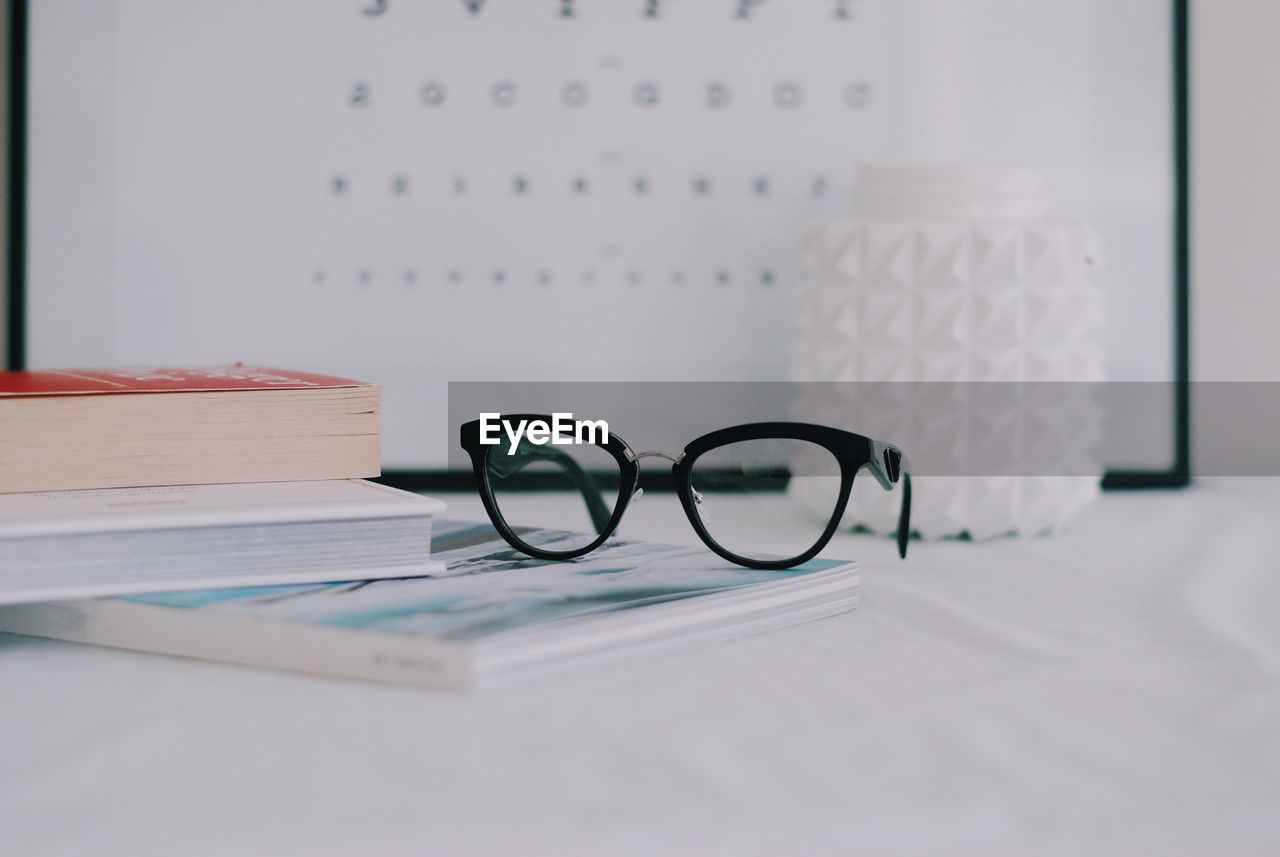 Close-up of books with eyeglasses on table