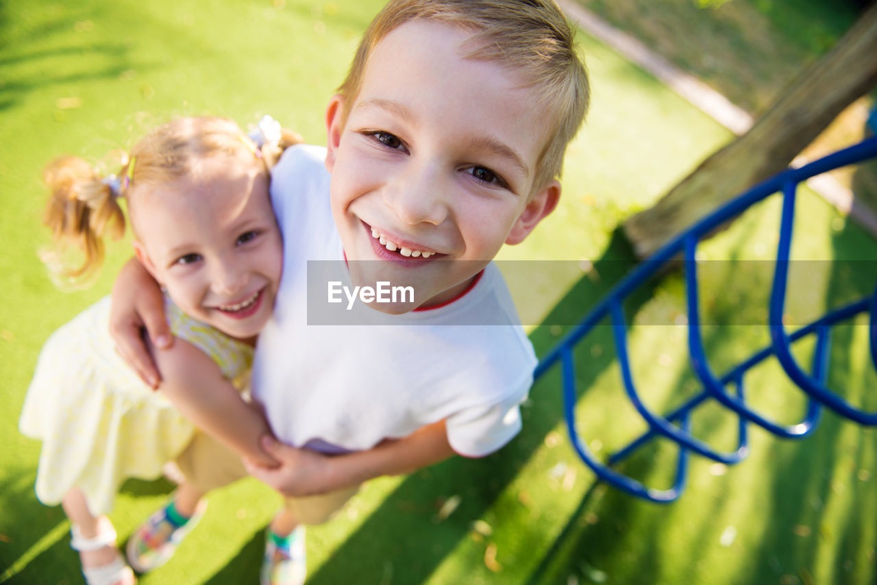 Portrait of cute sibling standing outdoors