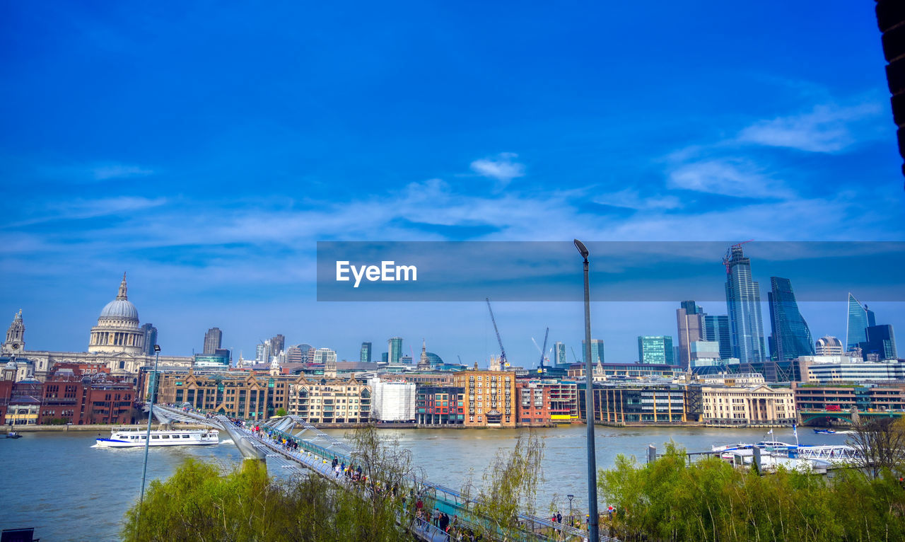 View of buildings at waterfront against cloudy sky