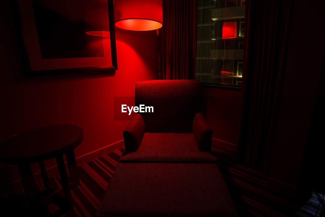 Empty chair in illuminated room