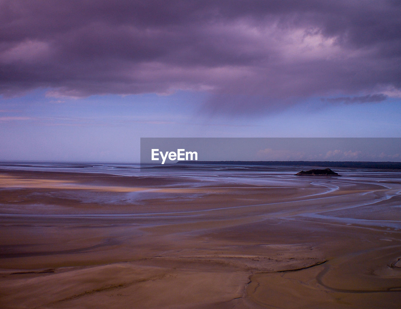 Scenic view of beach and sea against cloudy sky