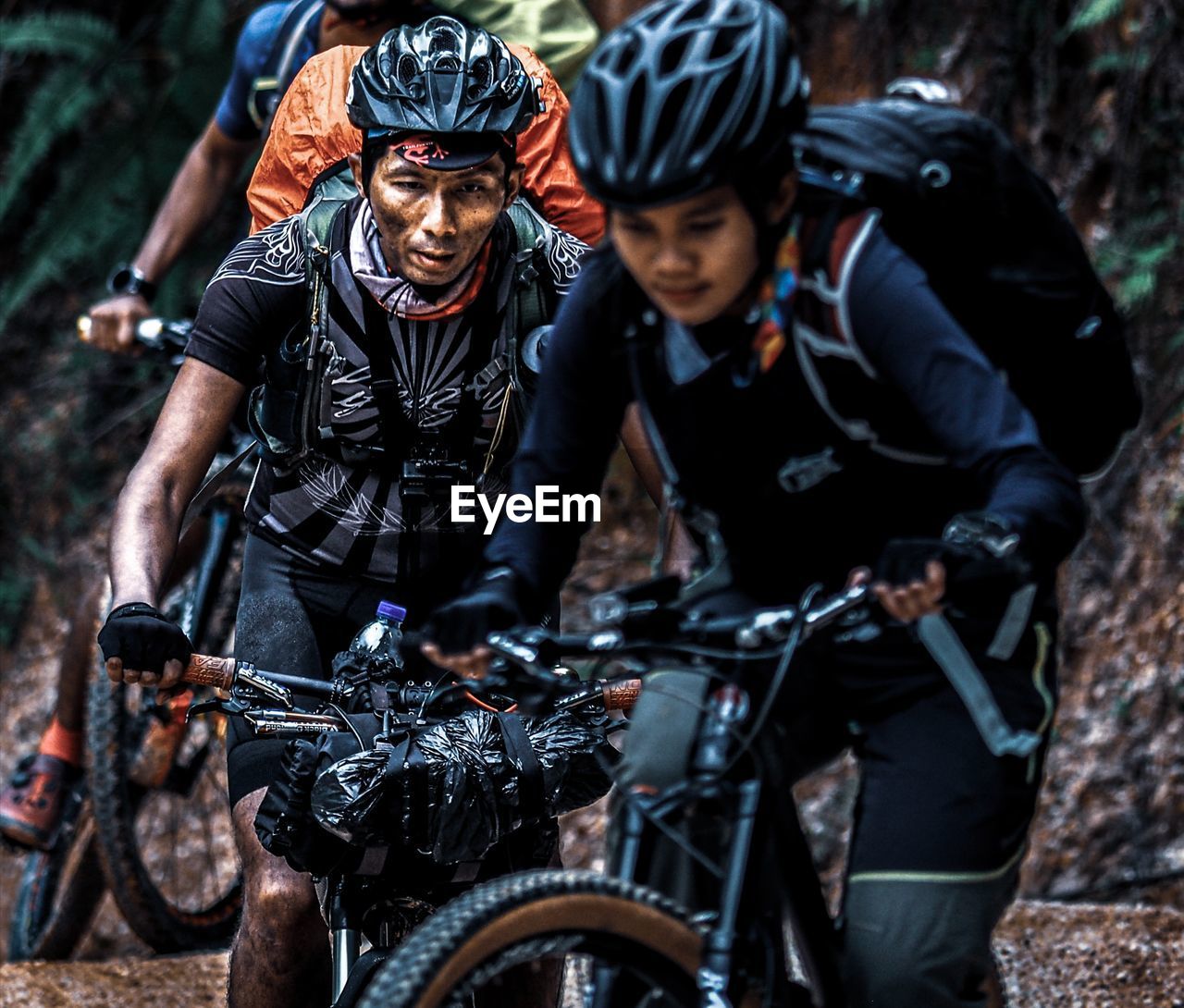 YOUNG MAN RIDING BICYCLE ON MOTORCYCLE AGAINST BLURRED BACKGROUND