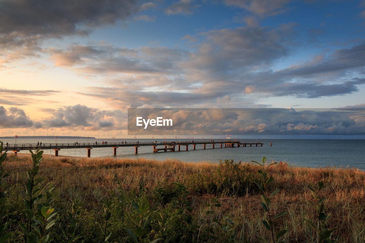 SCENIC VIEW OF BEACH AGAINST SKY DURING SUNSET