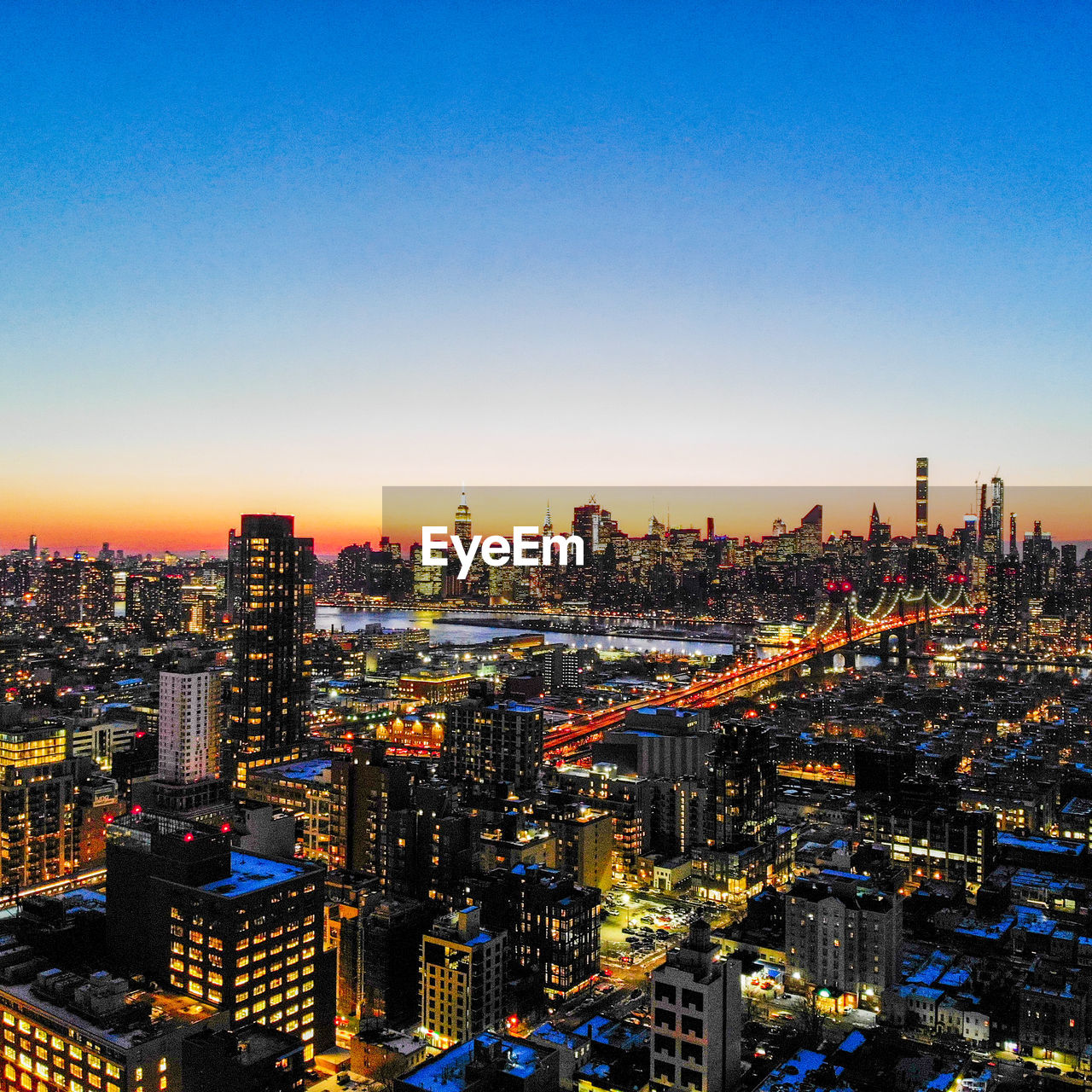 ILLUMINATED CITY AGAINST CLEAR SKY