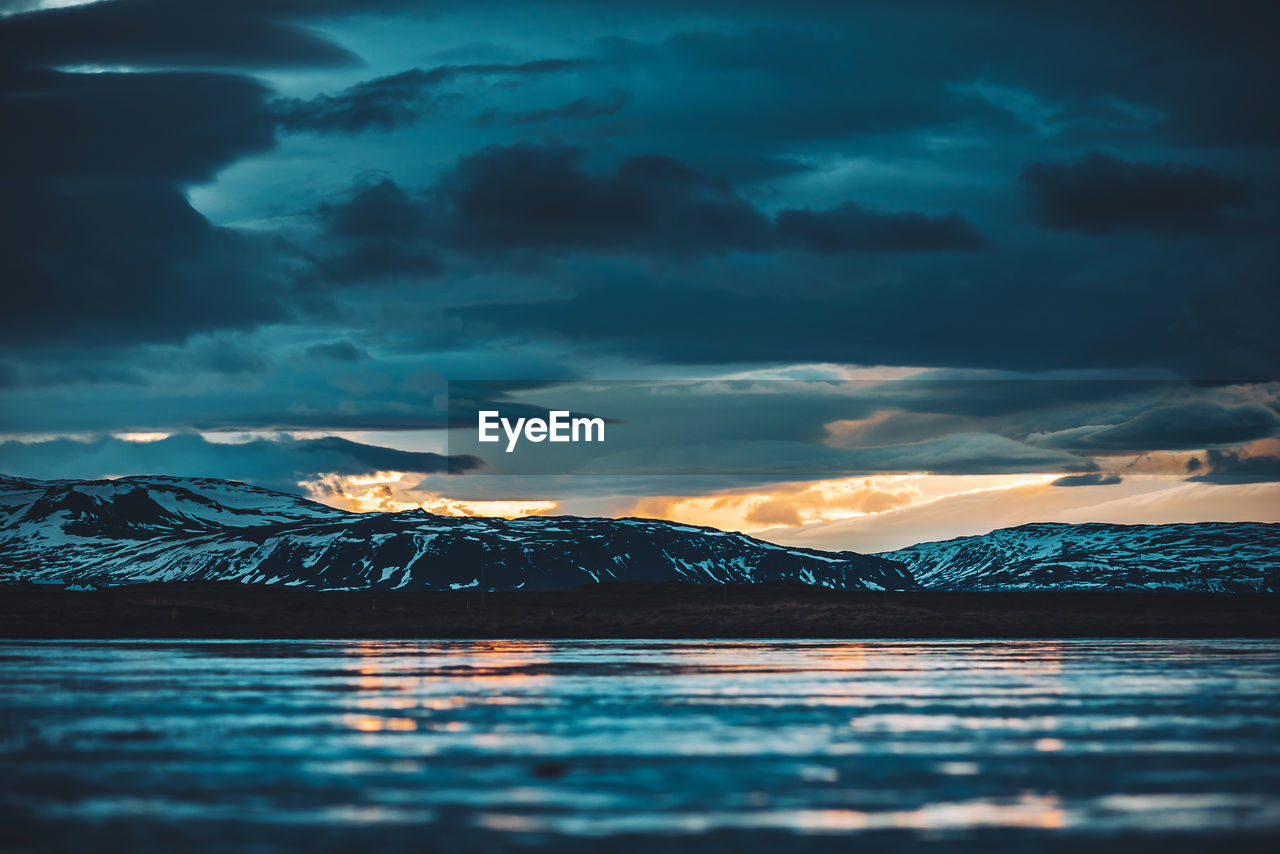 Scenic view of snowcapped mountains against sky during sunset