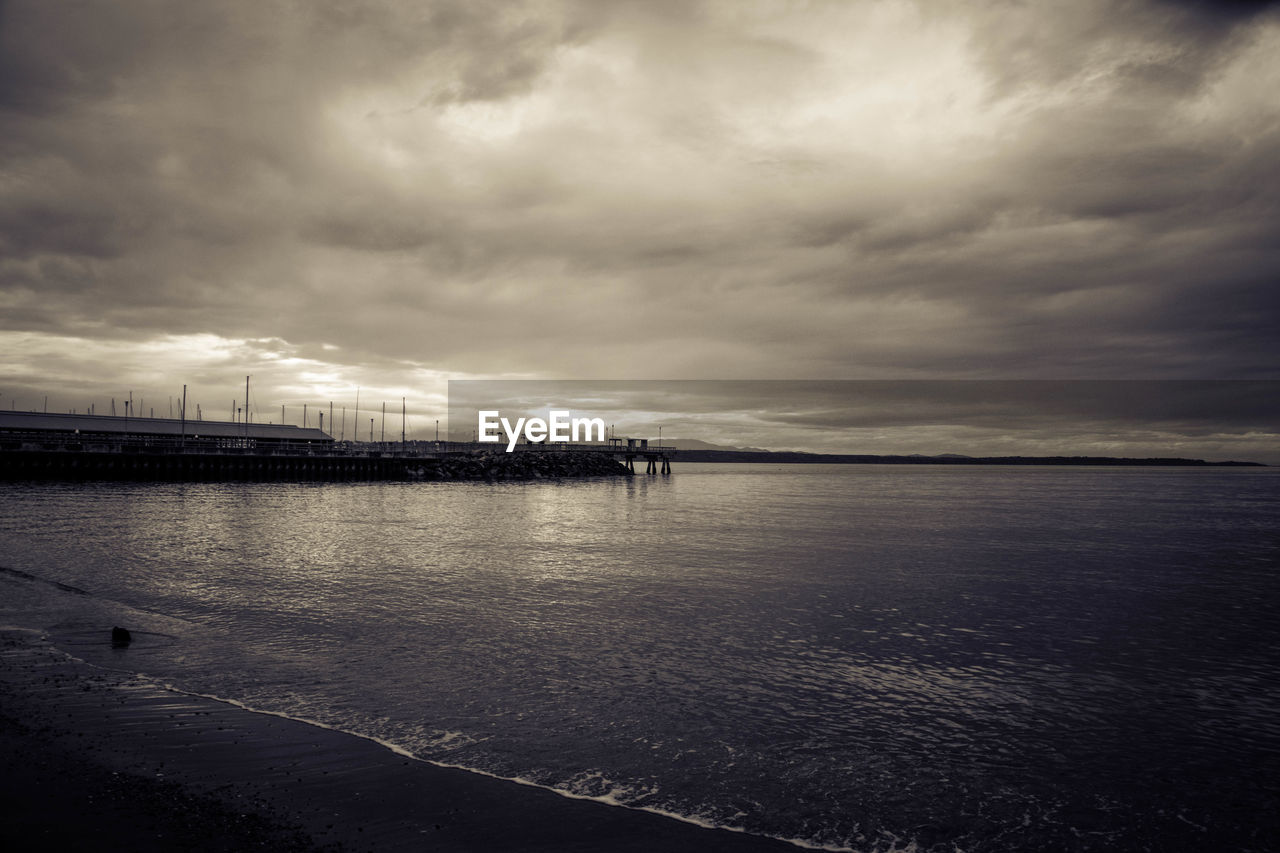 Scenic view of calm sea against cloudy sky