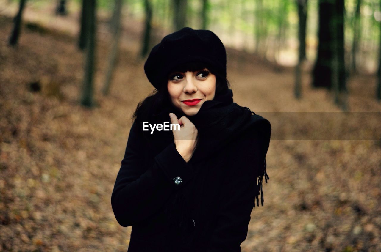 Beautiful woman with warm cloth standing in forest