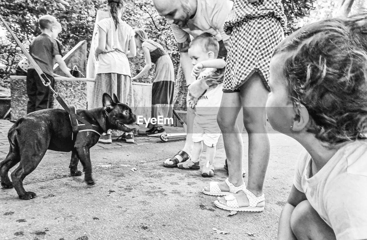 REAR VIEW OF PEOPLE WITH DOG ON STREET