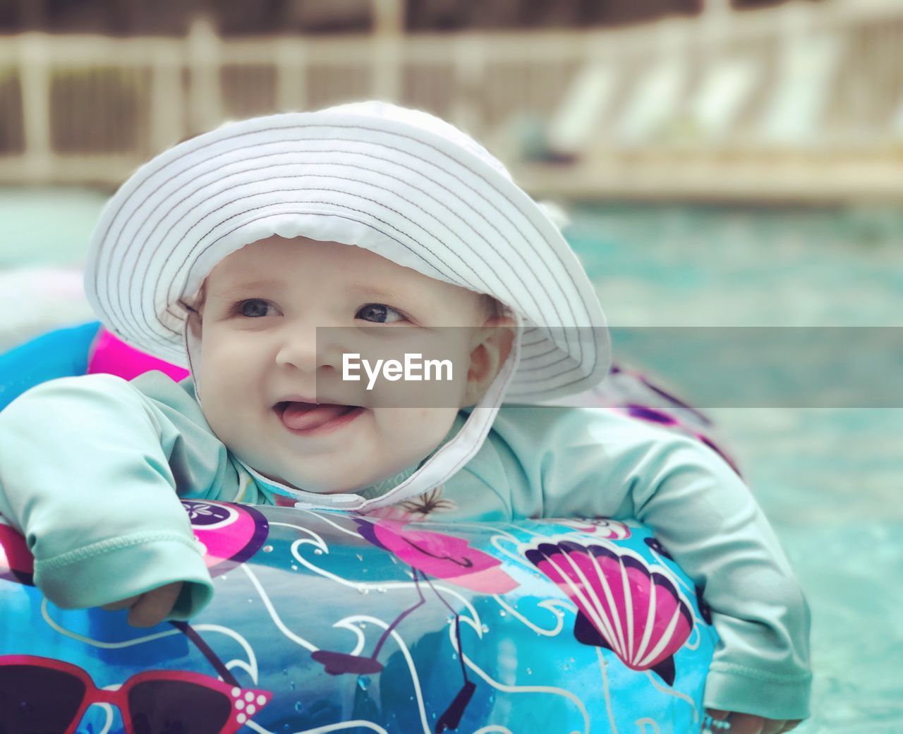 Close-up of cute baby girl in inflatable ring floating on swimming pool