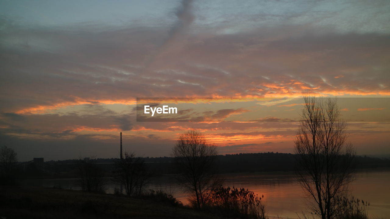 SILHOUETTE TREES BY LAKE AGAINST SKY AT SUNSET