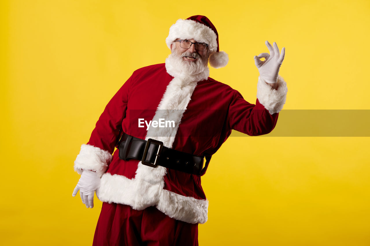 Santa claus making the ok gesture on yellow background