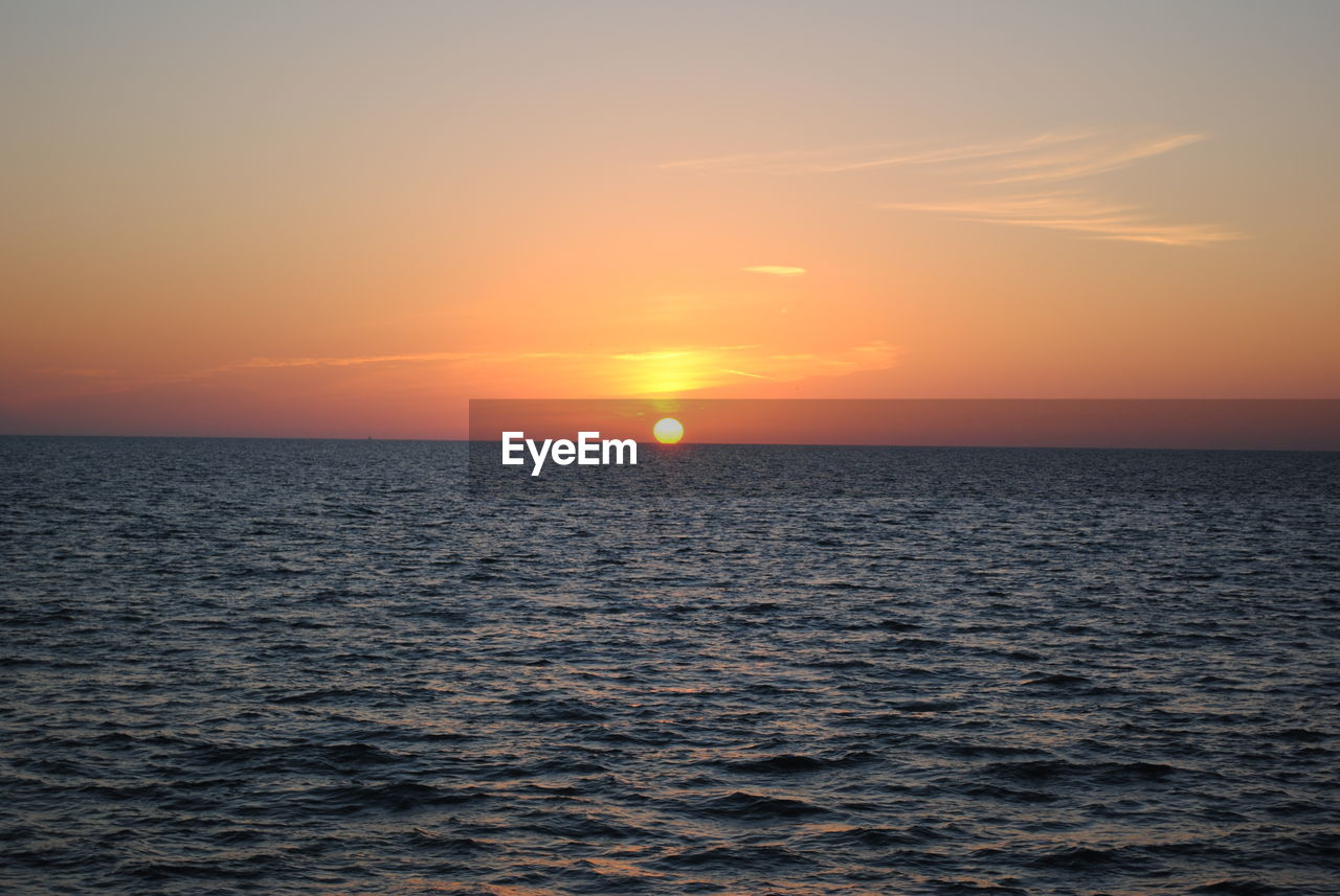 SCENIC VIEW OF SEA AGAINST ORANGE SKY
