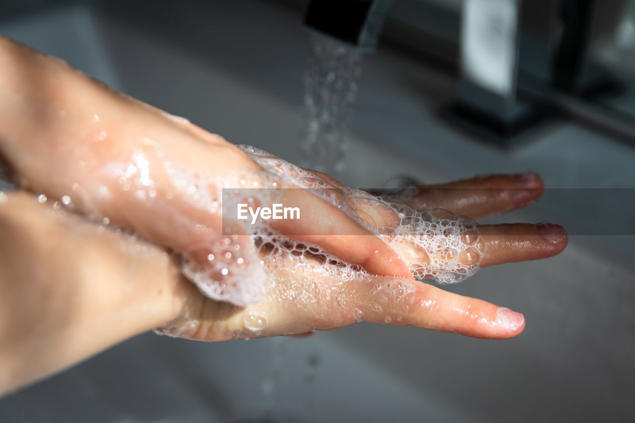 CLOSE-UP OF WOMAN HAND WITH WATER DROP