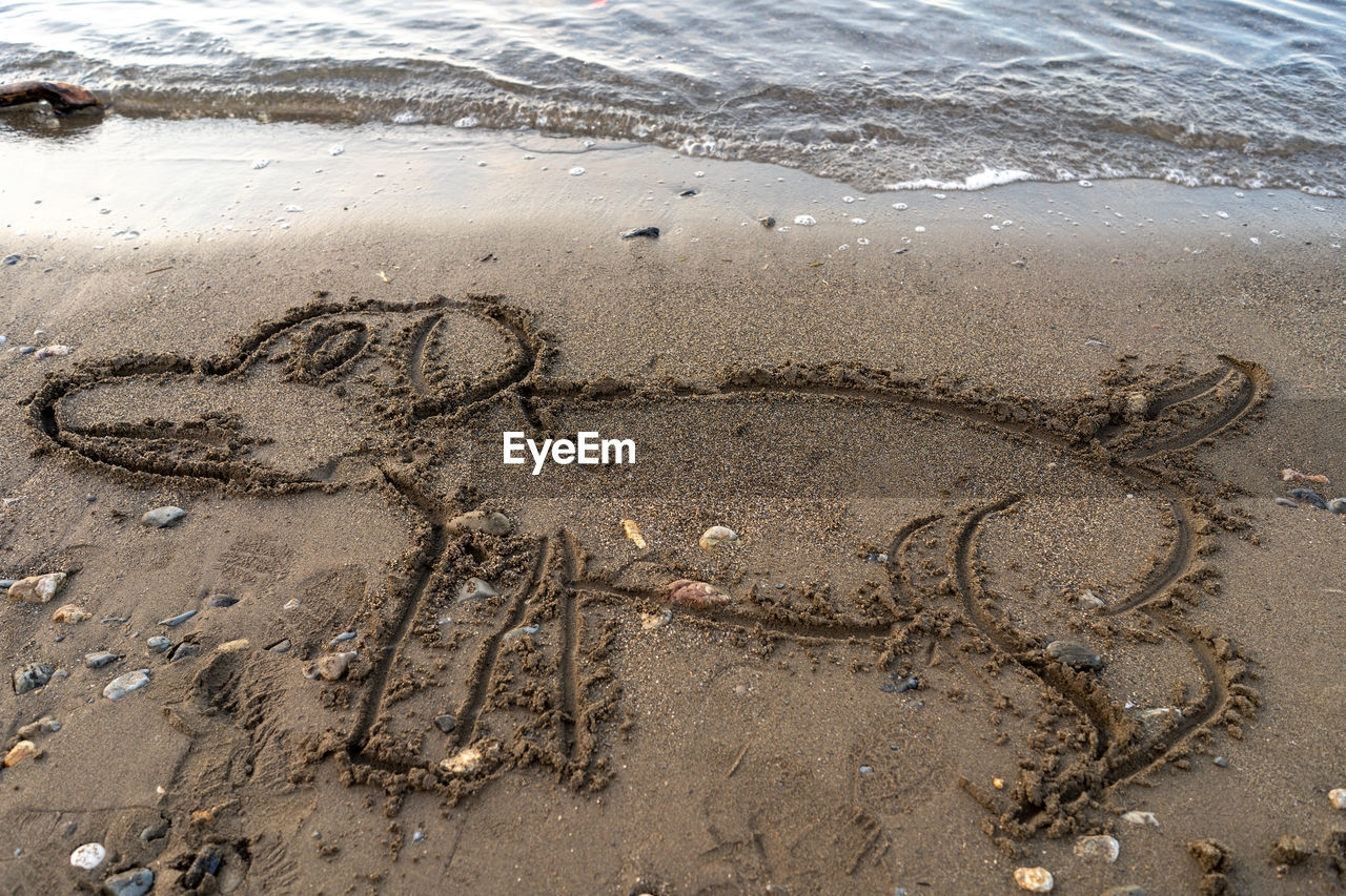 HIGH ANGLE VIEW OF HEART SHAPE ON SAND AT BEACH