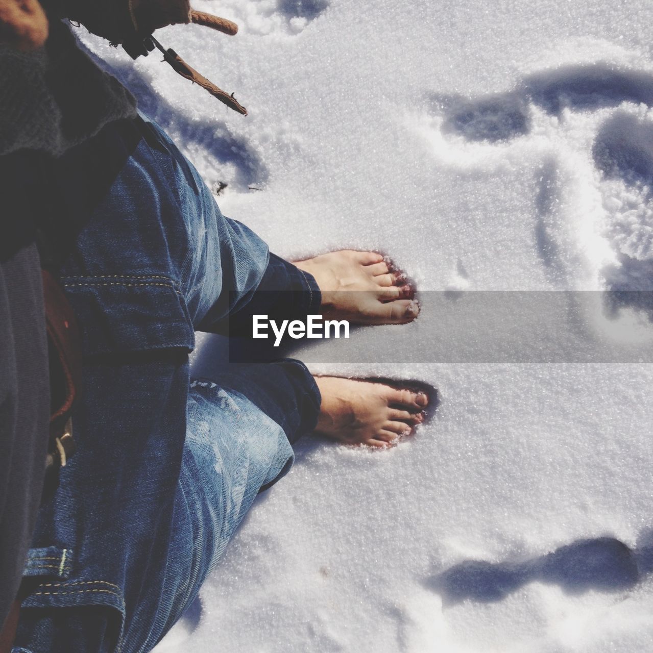 Low section of man standing on snowy land