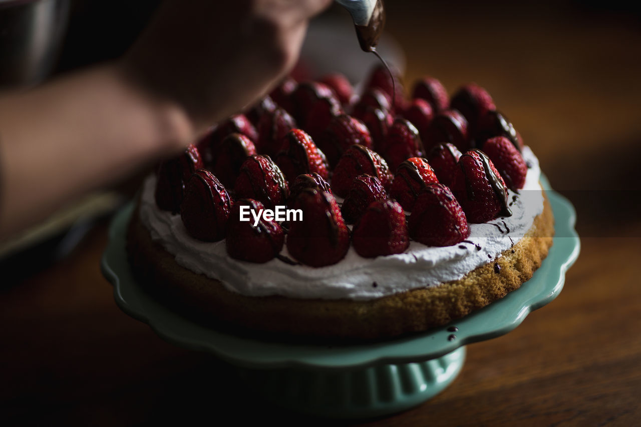 CLOSE-UP OF HAND HOLDING CAKE SLICE