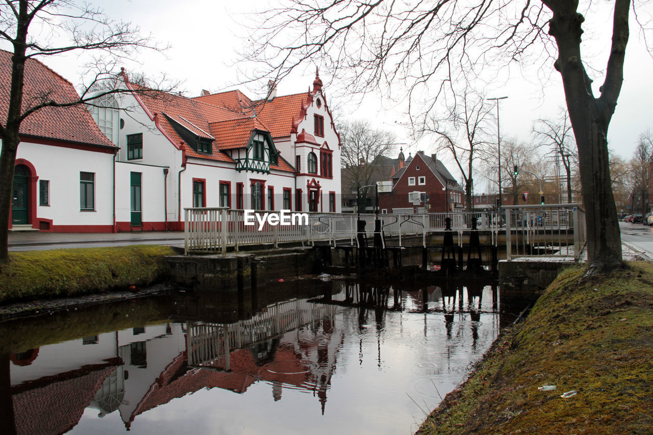 HOUSES BY RIVER AGAINST SKY