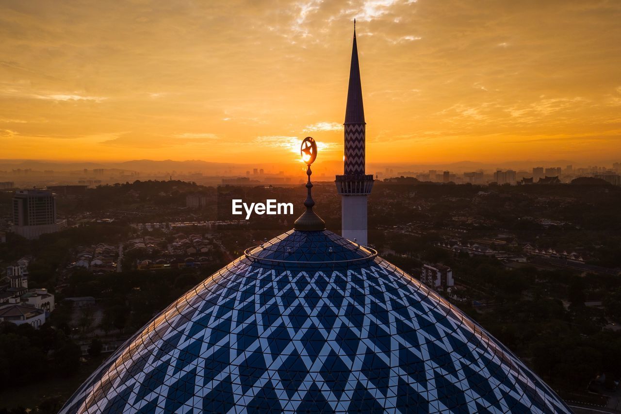 High section of mosque against sky during sunset