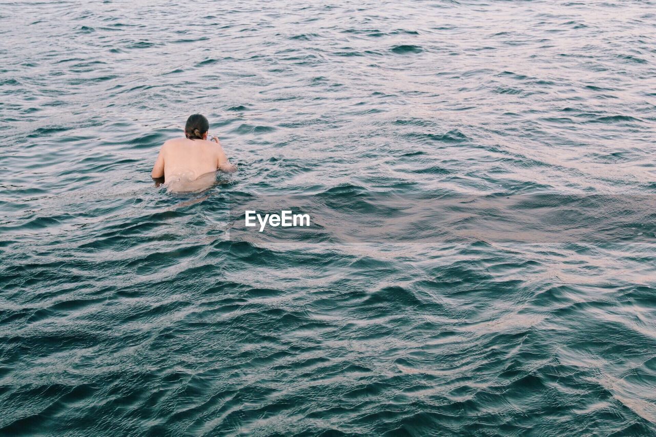 Rear view of man swimming in sea