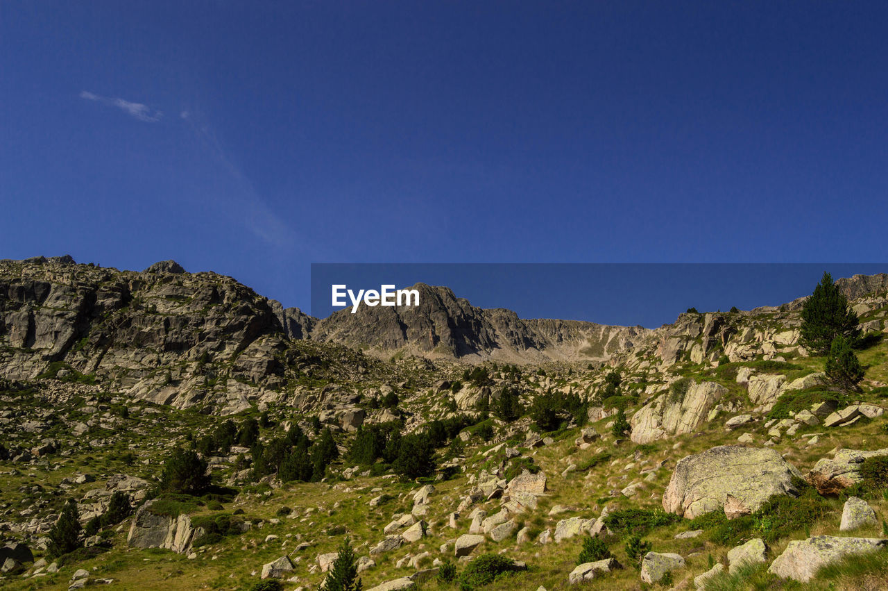 Scenic view of rocky mountains against clear blue sky