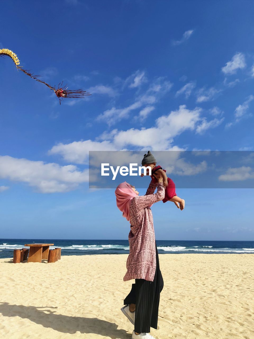 Low section of person on beach against sky