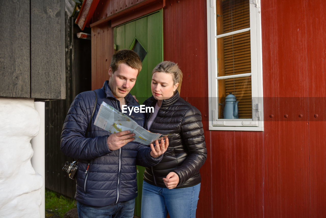 Traveling couple reading map in town