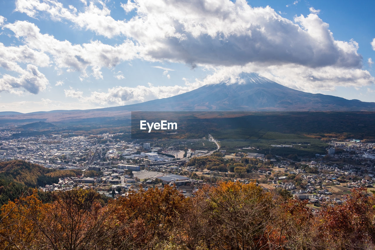 AERIAL VIEW OF CITYSCAPE AND MOUNTAINS AGAINST SKY