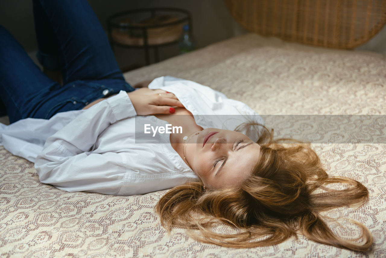 High angle view of woman lying on bed at home