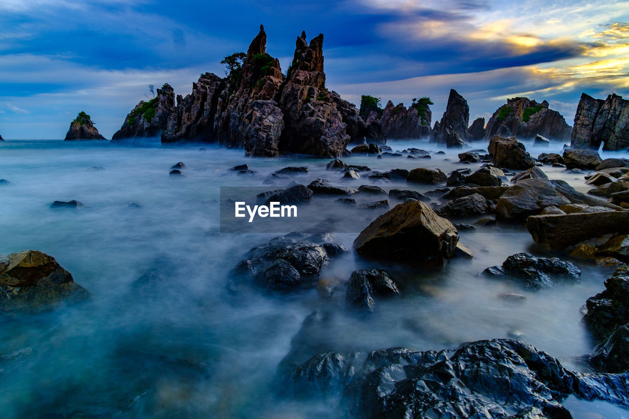 Scenic view of rocks in sea against sky