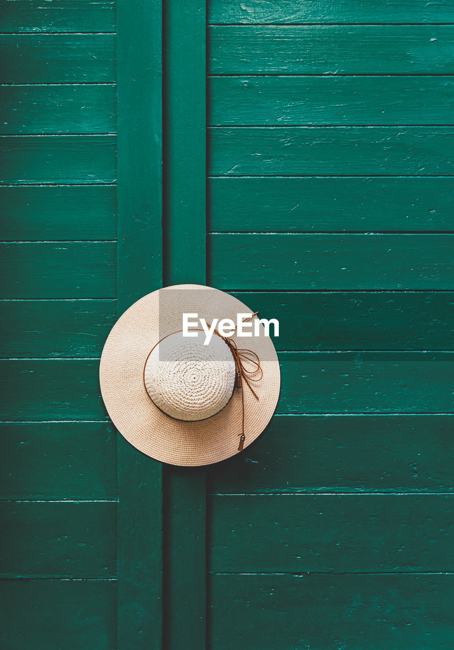 Hat on green door. minimalist, minimalism, entrance.