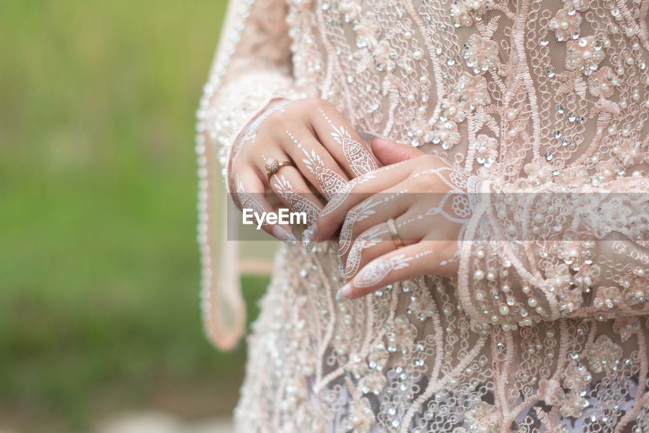 wedding dress, adult, women, hand, bride, dress, one person, wedding, gown, jewelry, life events, bridal clothing, event, clothing, newlywed, midsection, celebration, ring, wedding ring, nature, female, fashion, close-up, focus on foreground, lace, positive emotion, emotion, outdoors, lace - textile, love, married, day, fashion accessory, lifestyles, young adult, wedding ceremony